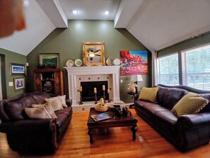 TV connectée, cheminée, livres, chaîne hi-fi