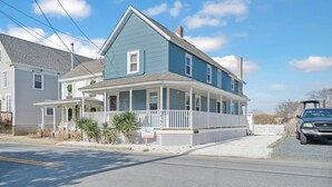 A two-story house with a porch, a garage, and a driveway. - Family Tides by Seaside Vacations & Sales (Chincoteague Island)