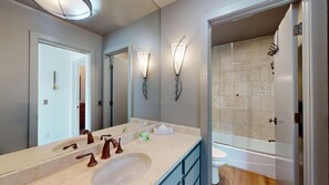 A bathroom with a large mirror, a sink with two faucets, a toilet, and a shower area. - Knob Hill Ridge Townhome 1 - Modern Decor Right in Downtown and Pet Friendly (Ketchum)