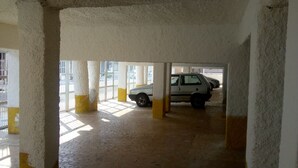 A parking garage with concrete pillars and a tiled floor. - Kit to enjoy the beach, holidays and vacations  (Praia Grande)