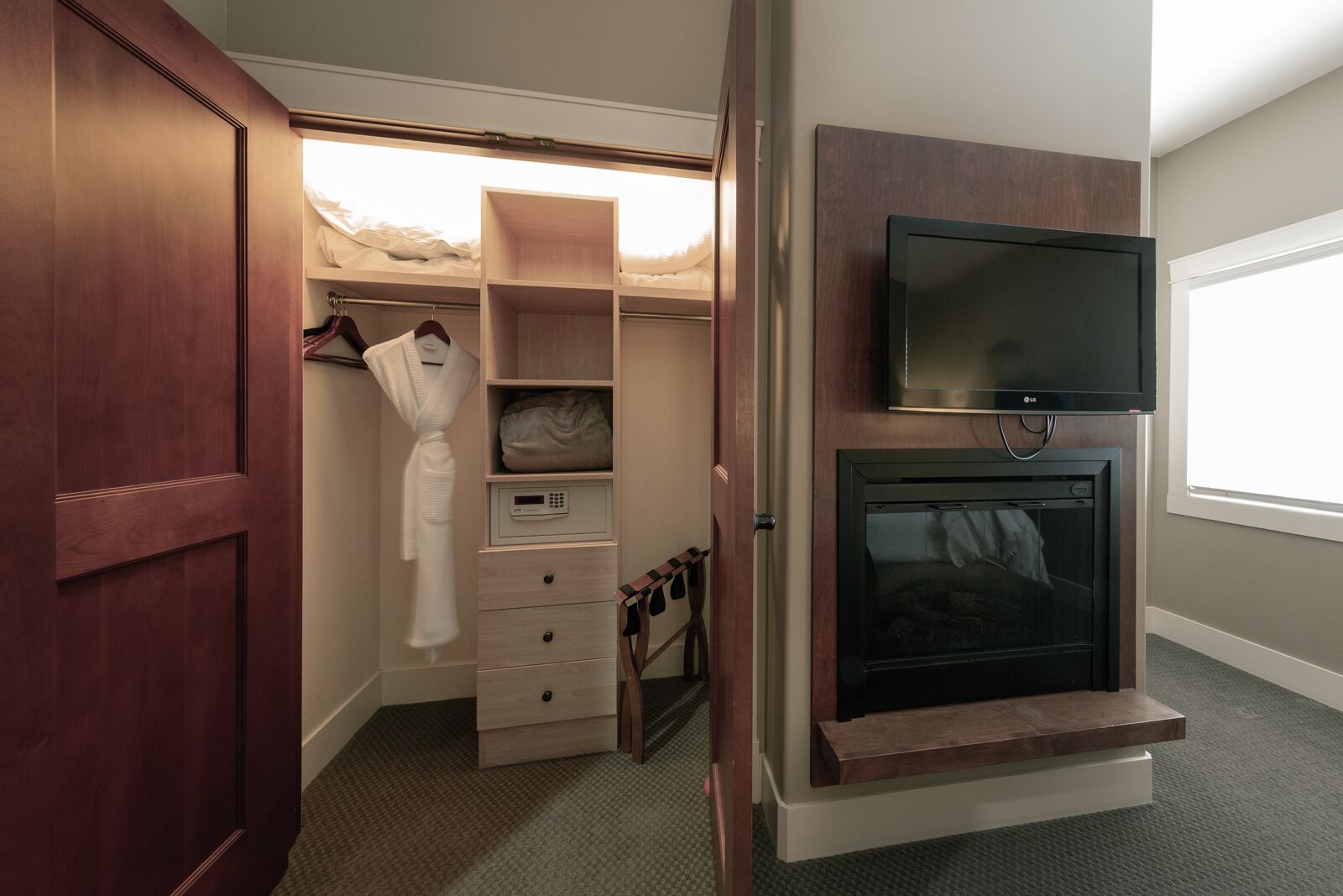 Une pièce de taille modeste, dotée d’une armoire, d’un téléviseur encastré et d’une cheminée.