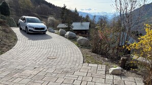 Un sentier pavé mène à un chalet offrant une vue sur la montagne.