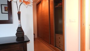 A hallway with a wooden floor, a wooden door, and a wooden wardrobe with multiple drawers. - Frontline Townhouse, Beautifully Furnished, Private Pool, Full a/c, Wi-Fi (Torre Pacheco)