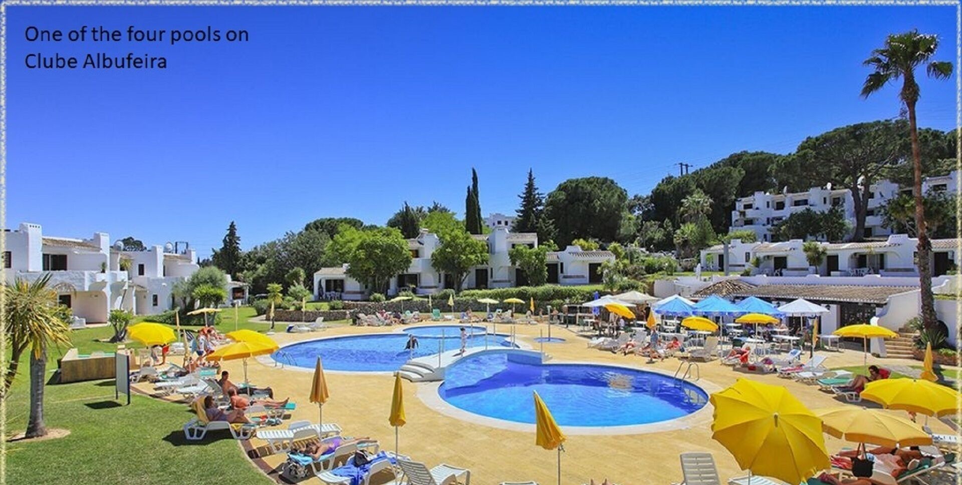 Ein Resort mit mehreren Schwimmbecken, Liegestühlen und Sonnenschirmen.