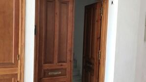 A wooden door with a brass handle and a small brass plate above it.