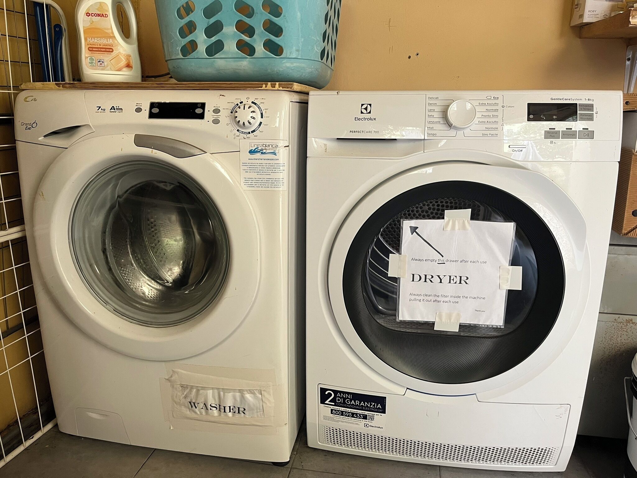 Two stacked washing machines, one labeled 'WASHER' and the other 'DRYER', with a label indicating a 2-year warranty.