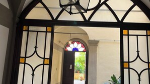 An arched doorway with a decorative metal gate and a stained glass window above.