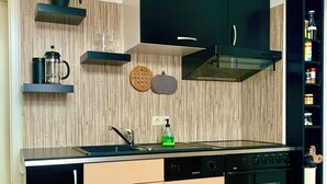 A modern kitchen with a dishwasher, oven, and a coffee maker on the countertop.