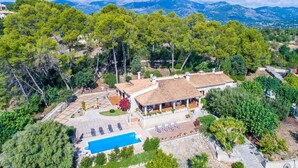 An aerial view of a villa with a swimming pool, surrounded by lush greenery and mountains in the background. - Rural finca in Mallorca Es Bosquet with pool (Inca)