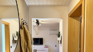 Moderni sisustus, jossa on puulattia, peiliseinä ja upotetuilla valaisimilla varustettu katto.