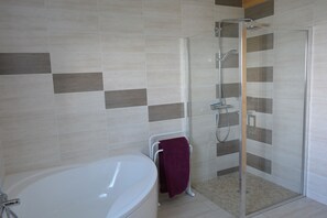 Bañera con ducha, secador de pelo, papel higiénico
