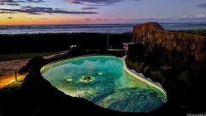 A swimming pool with a view of the ocean at sunset. - Beach Front Estate with Guest Cottage, Sandy Beach, Heated Pool. Please Inquire (Waialua)