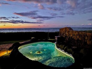 Piscina com vista para o oceano ao pôr do sol.