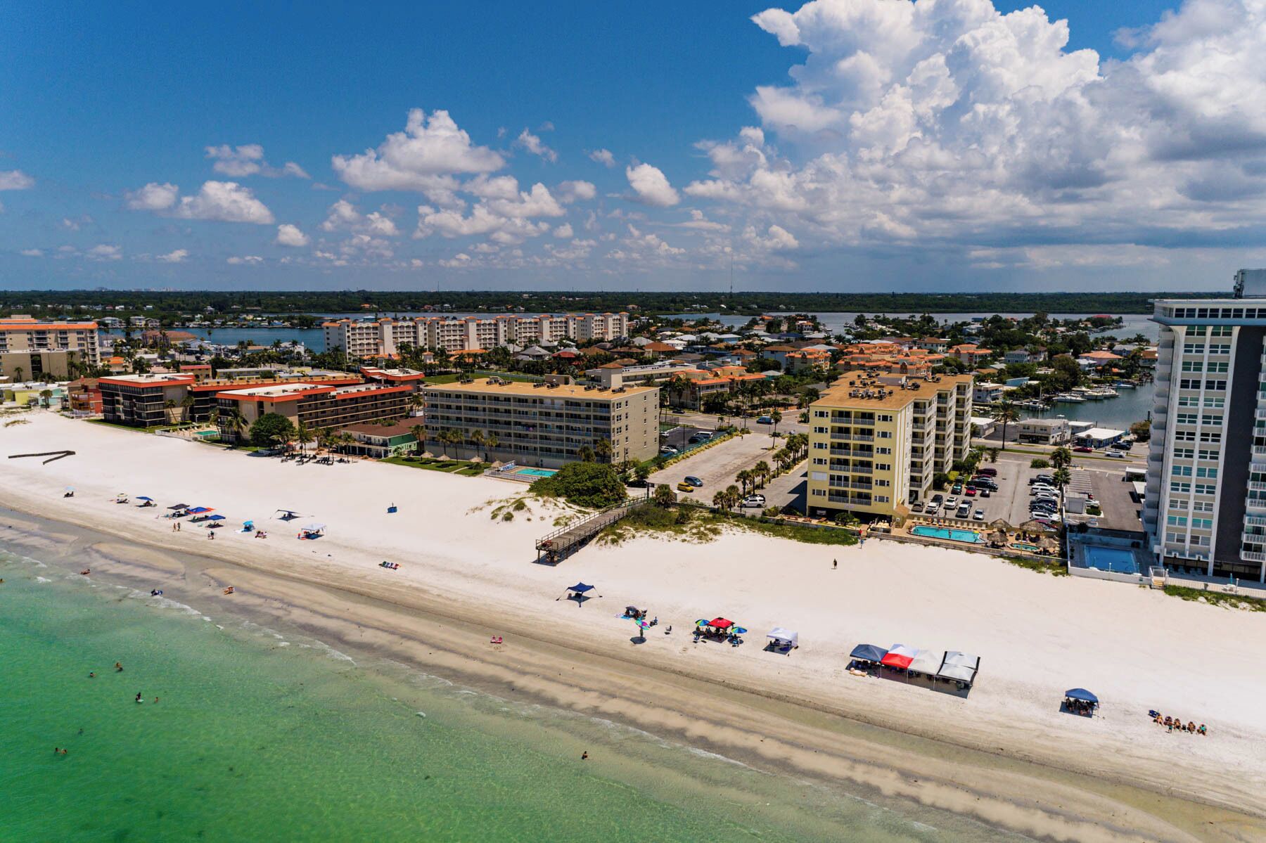 A coastal resort with beachfront hotels, a sandy beach, and clear turquoise waters.