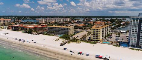 A coastal resort with beachfront hotels, a sandy beach, and clear turquoise waters.