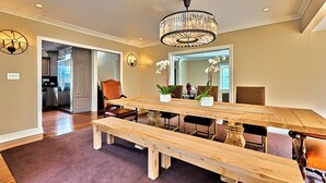A dining area with a wooden table, benches, chairs, a chandelier, and a view into the kitchen. - Summer Sun - Magnificent Hollywood Hills HtdPool Residence in Celebrity Enclave (Los Angeles)