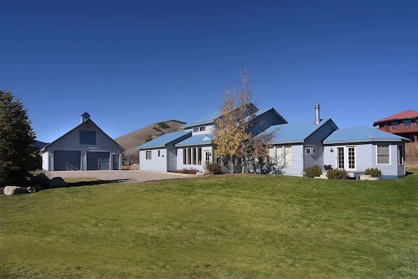 A residential area with houses featuring gabled roofs and a grassy lawn.