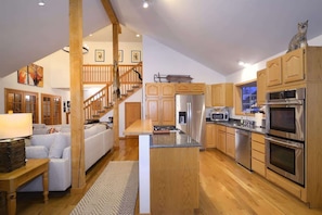 A spacious kitchen with wooden cabinets, stainless steel appliances, and a central island.