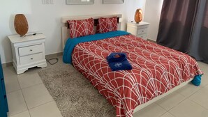 A neatly arranged bedroom with a bed, nightstands, and a rug. - NEW Amazing Ocean View - 301C (boca chica)