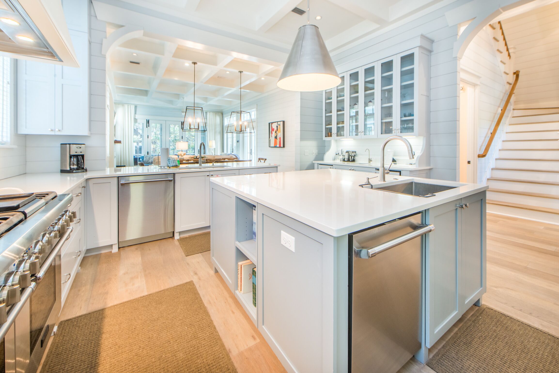 A modern kitchen with a central island, stainless steel appliances, and a large pendant light.