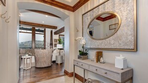 A modern interior with a large mirror, a console table, and a view through a window.
