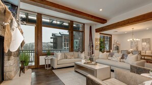 A spacious living room with a large sofa set, a coffee table, and a fireplace.