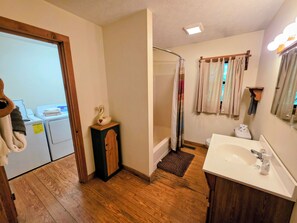 Ein Badezimmer mit Dusche, Waschbecken und einem Holzschrank.