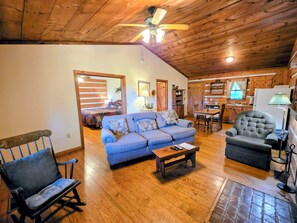 A cozy living room with a blue sofa, a wooden rocking chair, a grey armchair, and a dining table with chairs. - B's Nest a Private & Clean w Mtn Views & Hot Tubs! (Sevierville)