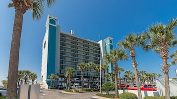 A multi-story hotel with a modern design, featuring a prominent tower and a series of balconies.