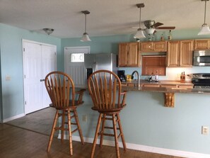Enjoy cooking in this well-equipped kitchen with a central island, dining table, and modern appliances.