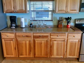 Kitchen features an oven, coffee maker, and ample counter space.