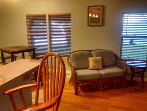 Relax in this inviting space with a dining table, armchair, and framed artwork.