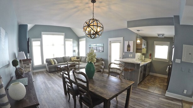 A spacious living area with a dining table, wooden chairs, and a modern chandelier. - Short walk to the village-Stunning upgraded Rivergrass condo w/ beautiful decor (The Blue Mountains)