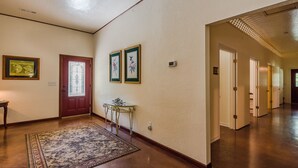 A hallway with a patterned rug, a small table, and framed artwork on the walls. - Hannah House ~ Your Vacation Awaits! (Huntsville)