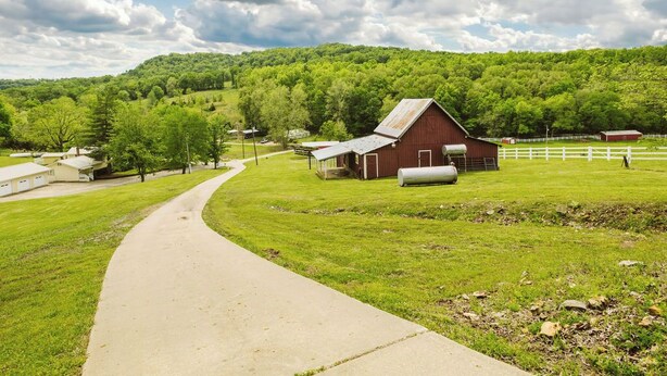A rural landscape with a red barn, a white fence, and a paved path. - Hannah House ~ Your Vacation Awaits! (Huntsville)