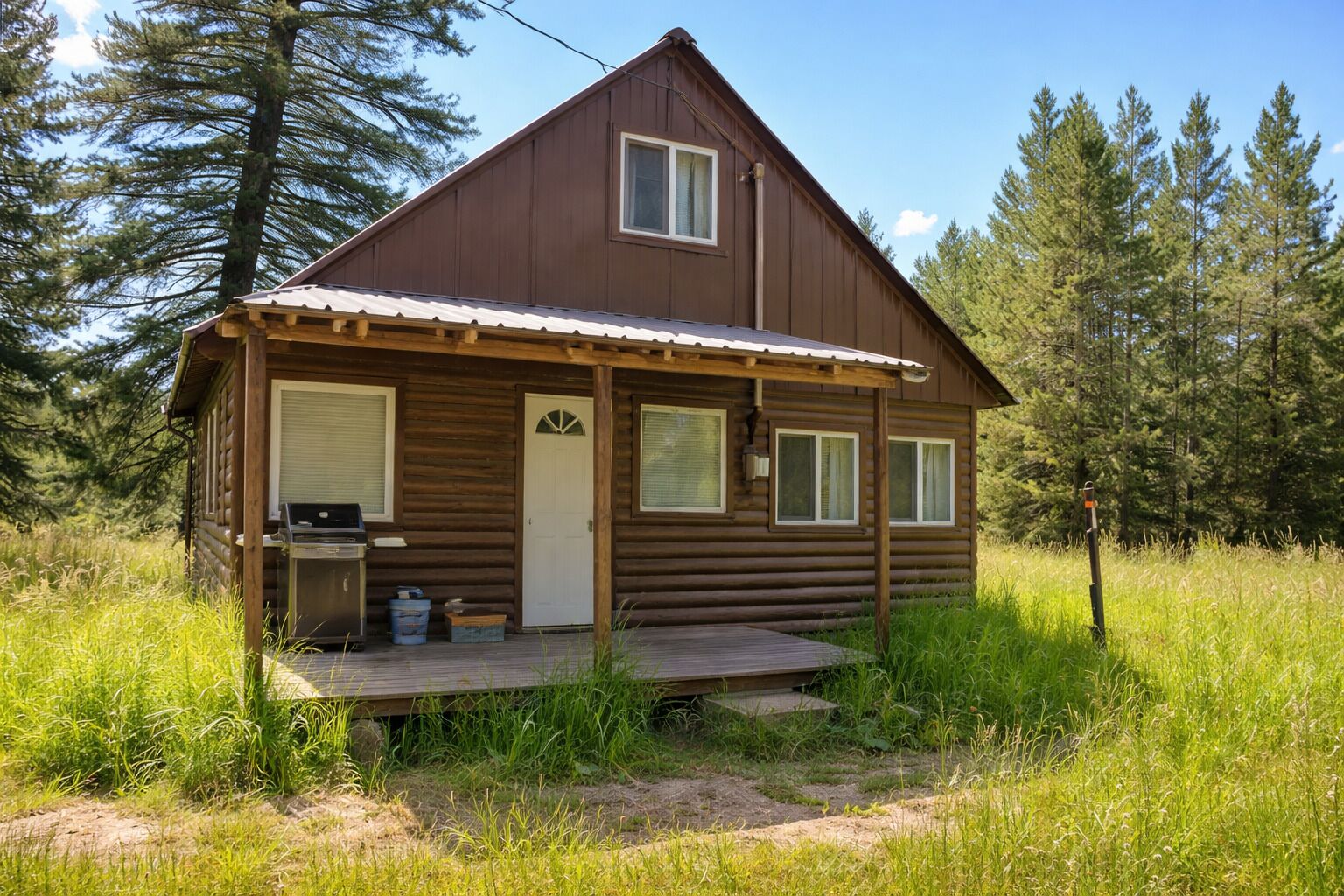 A small log cabin with a porch, a door, and a window.