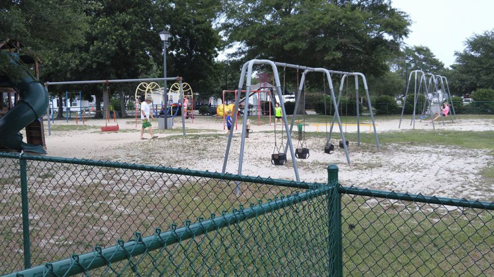 A playground with swings, a slide, and a climbing structure.