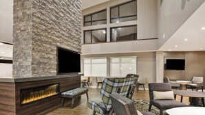 A modern lobby with a stone fireplace, comfortable seating, and a flat-screen TV. - Residence Inn by Marriott Cleveland Airport/Middleburg Heights (Middleburg Heights)