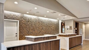 A reception area with a modern design, featuring a wooden wall and marble countertops. - Residence Inn by Marriott Cleveland Airport/Middleburg Heights (Middleburg Heights)