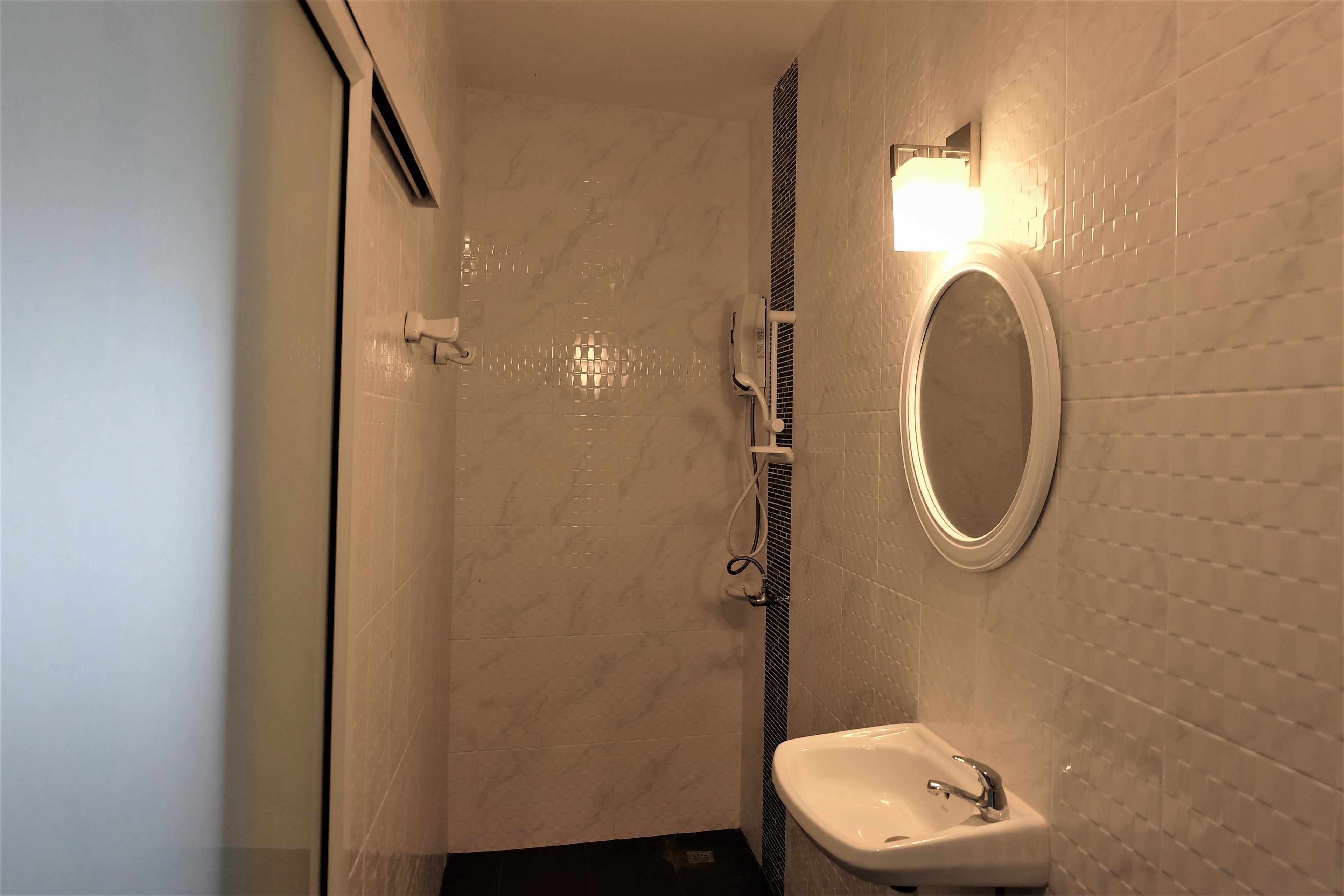 A bathroom with a shower, a sink, and a mirror.