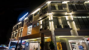 Un hôtel à plusieurs étages, doté d’une façade moderne, de balcons et d’une enseigne bien visible indiquant « Ammas Boutique Hotel ».