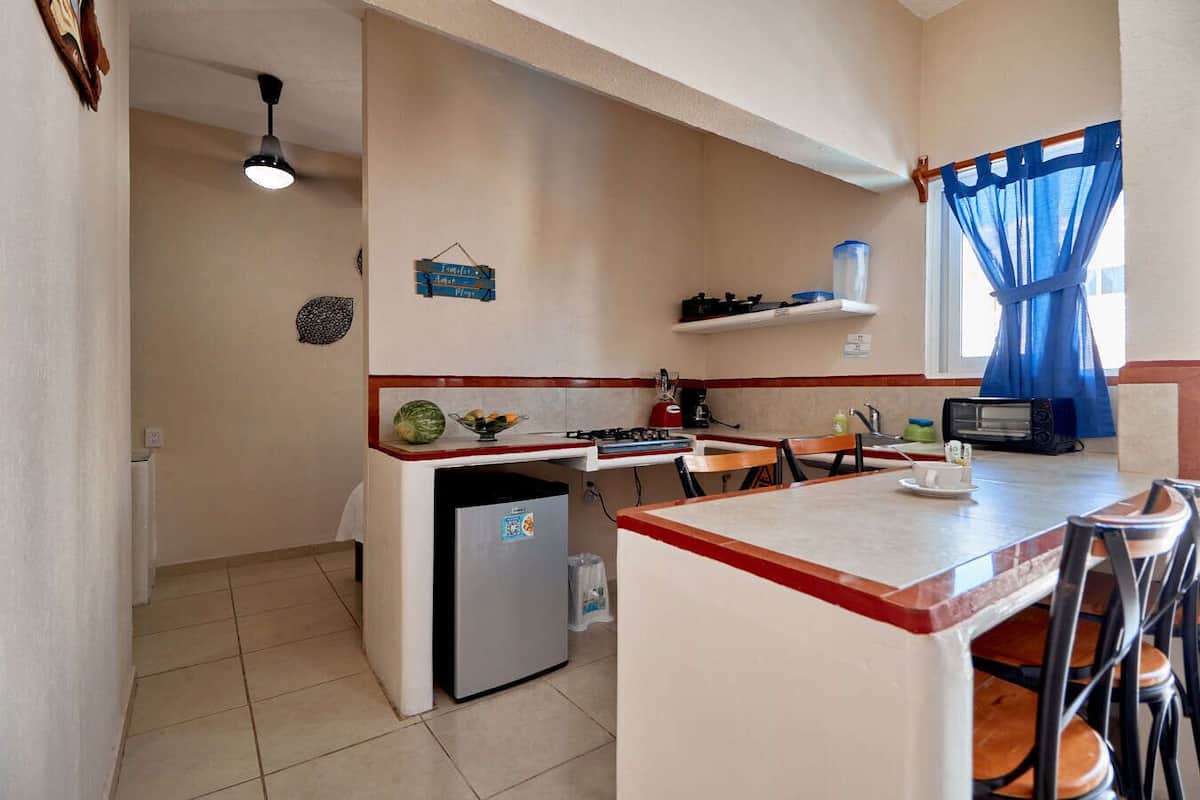 Una cocina compacta equipada con refrigerador, microondas, tostadora y lavaplatos.
