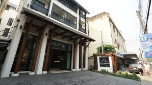 A building with a modern facade, a balcony, and a sign indicating a boutique hotel. - Anika Boutique Hotel (Chiang Mai)