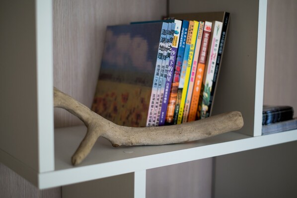 A bookshelf with a branch and books.