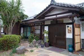 Ein traditionelles japanisches Gebäude mit einem Ziegeldach, Holzbalken und einer Schiebetür.