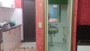 Un baño pequeño con lavamanos, espejo e inodoro.