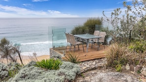Een terras met een tafel en stoelen met uitzicht op de oceaan.