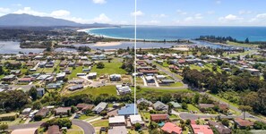 An aerial view of a residential area with houses, roads, and a beach.