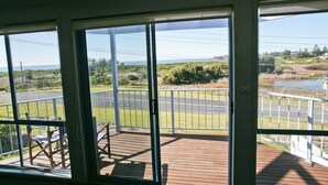 A balcony with a view of a road and greenery.