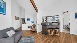 Ein modernes Wohnzimmer mit einem grauen Sofa, einem runden Couchtisch und Holzboden.